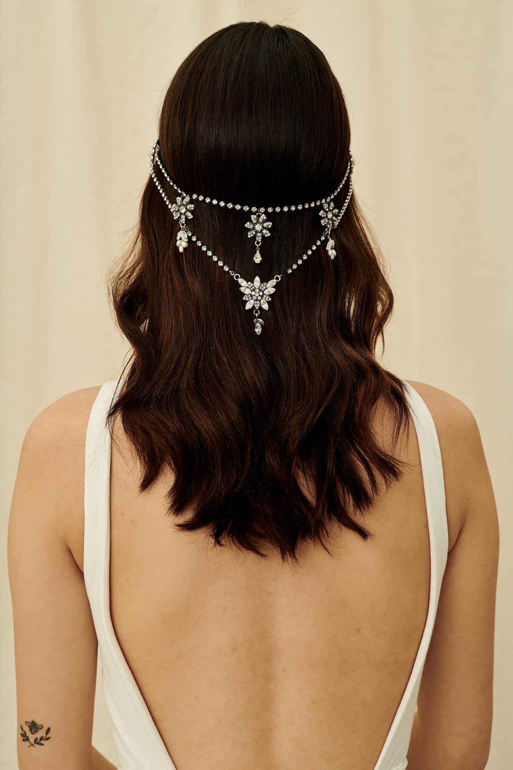 A Gatsby-inspired bridal hair accessory made with multiple strands of antique crystal chain and wired with freshwater pearls 