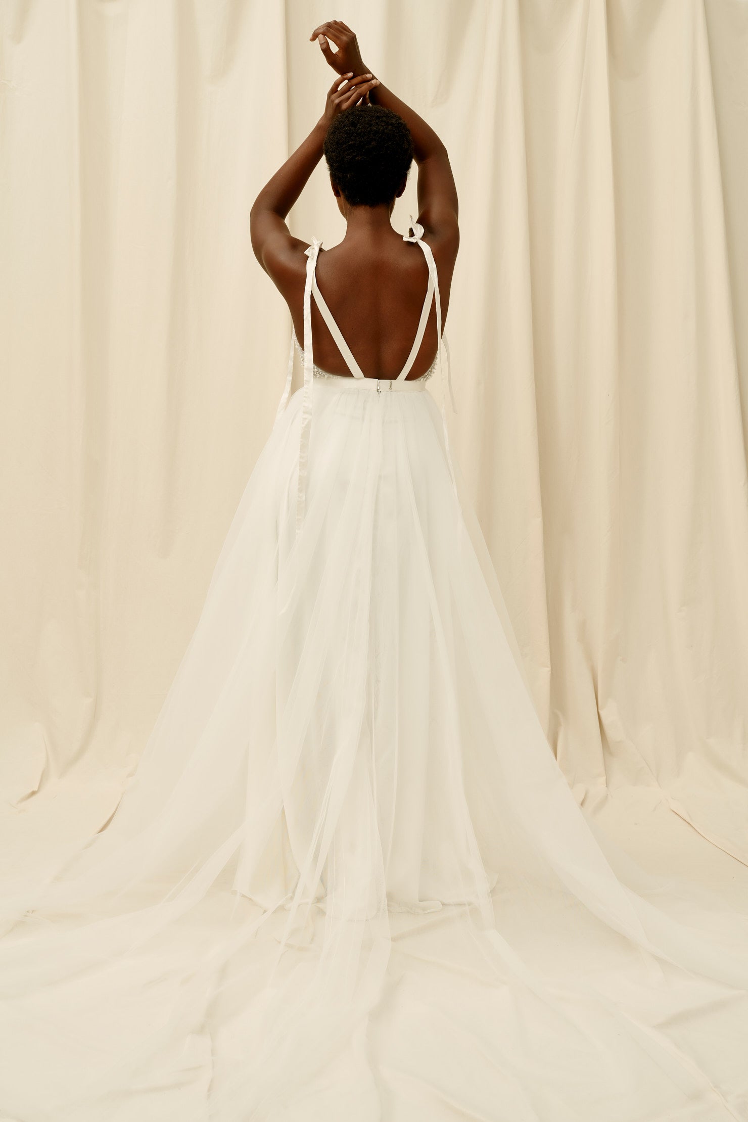 Open backed wedding dress with a soft tulle skirt and a long train