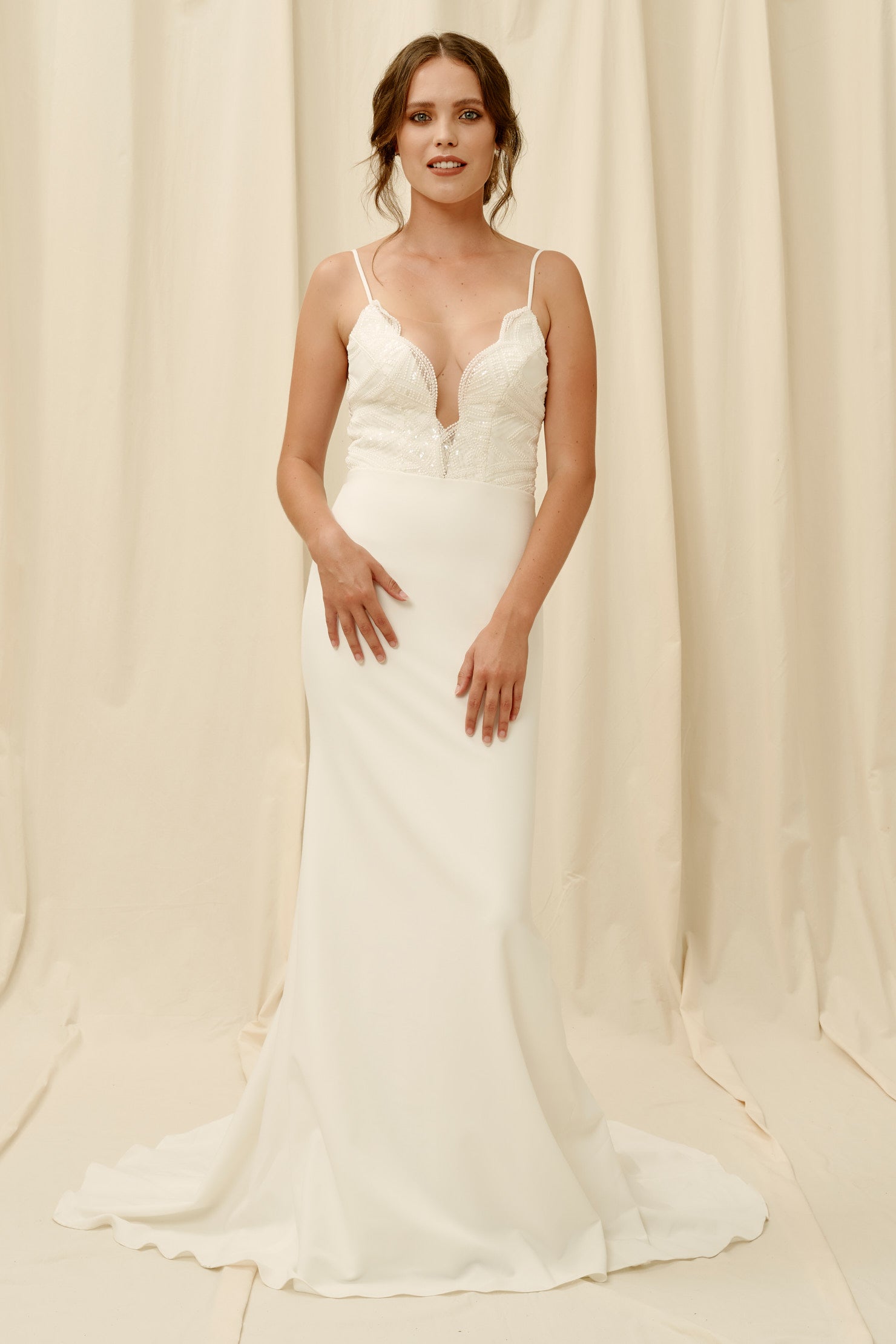 Fitted crepe wedding dress with a low neckline and spaghetti straps